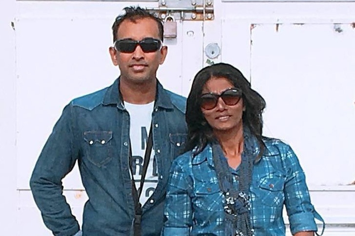 Upendra Ihalahewa and Darshika Withana standing in front of a white building.