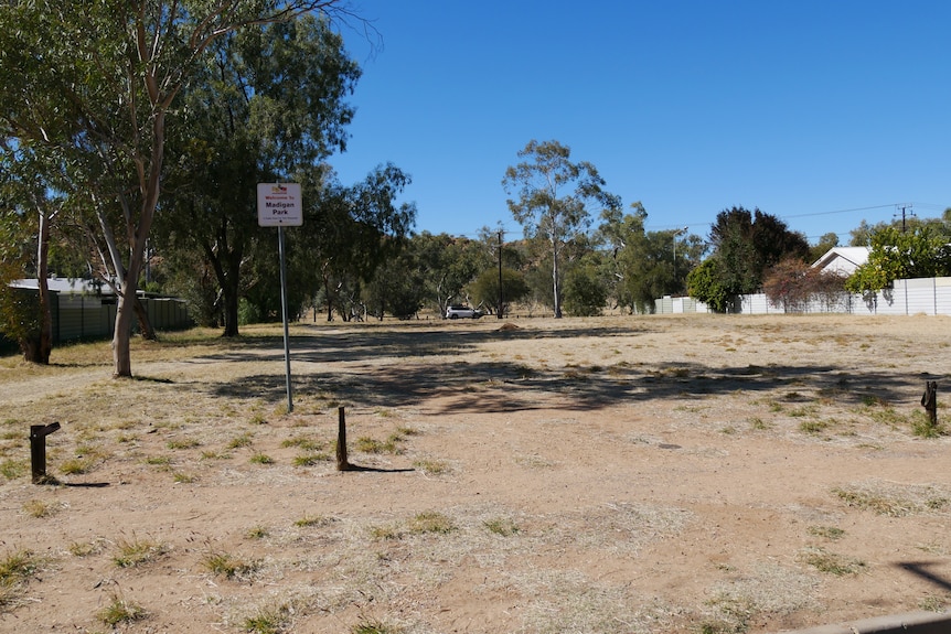 A rather bare park in a suburban area.