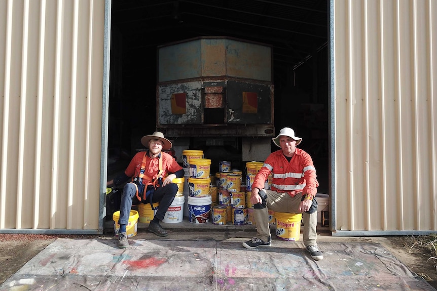 Artists' Zookeeper and Drapl sitting on paint tins