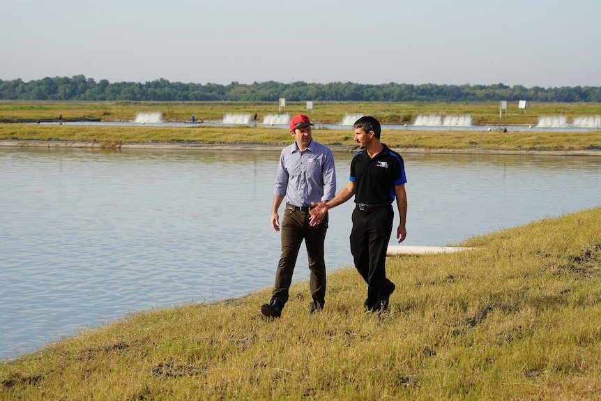 Matt Canavan walking with the owner of the Humpty Doo Barramundi Farm.