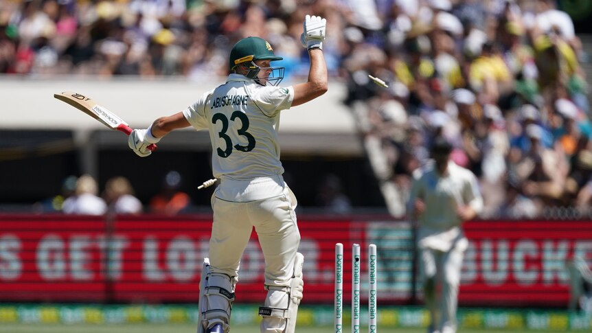 Marnus Labuschagne raises his arm and looks back as his bails fly.