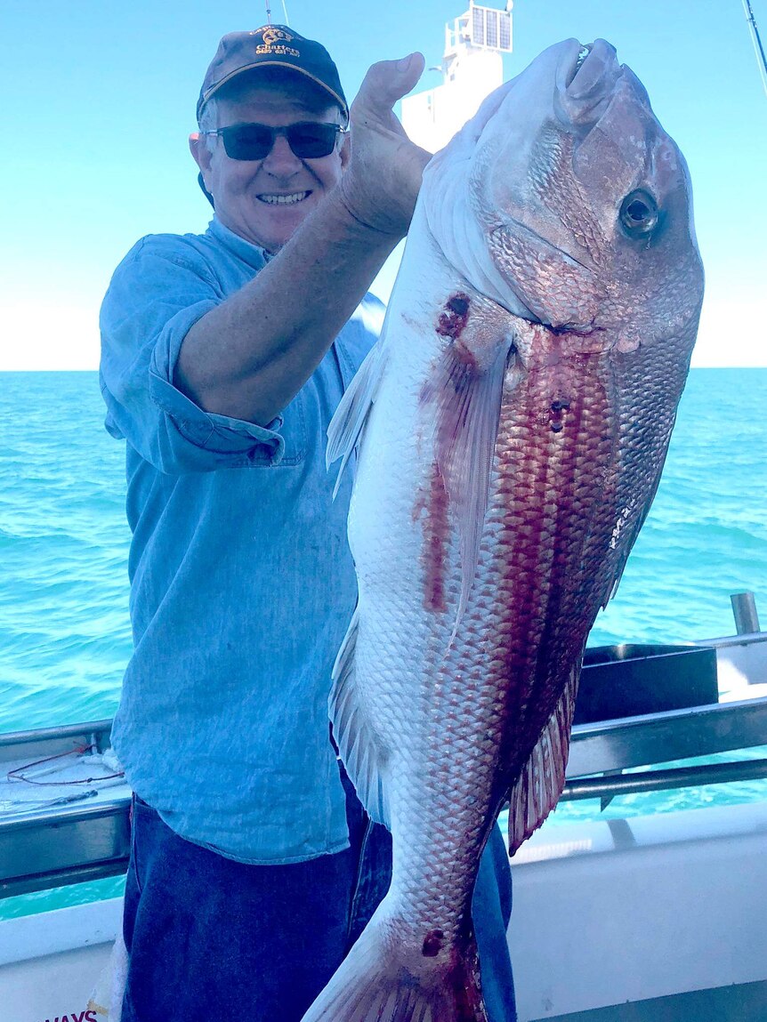 Fishing tour operator Ray Cook holds up a snapper.