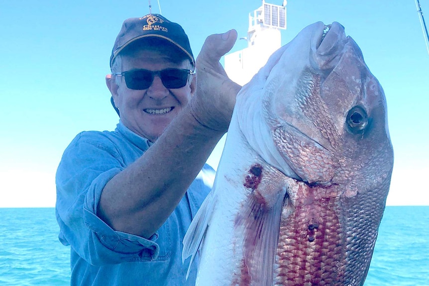 Fishing tour operator Ray Cook holds up a snapper.