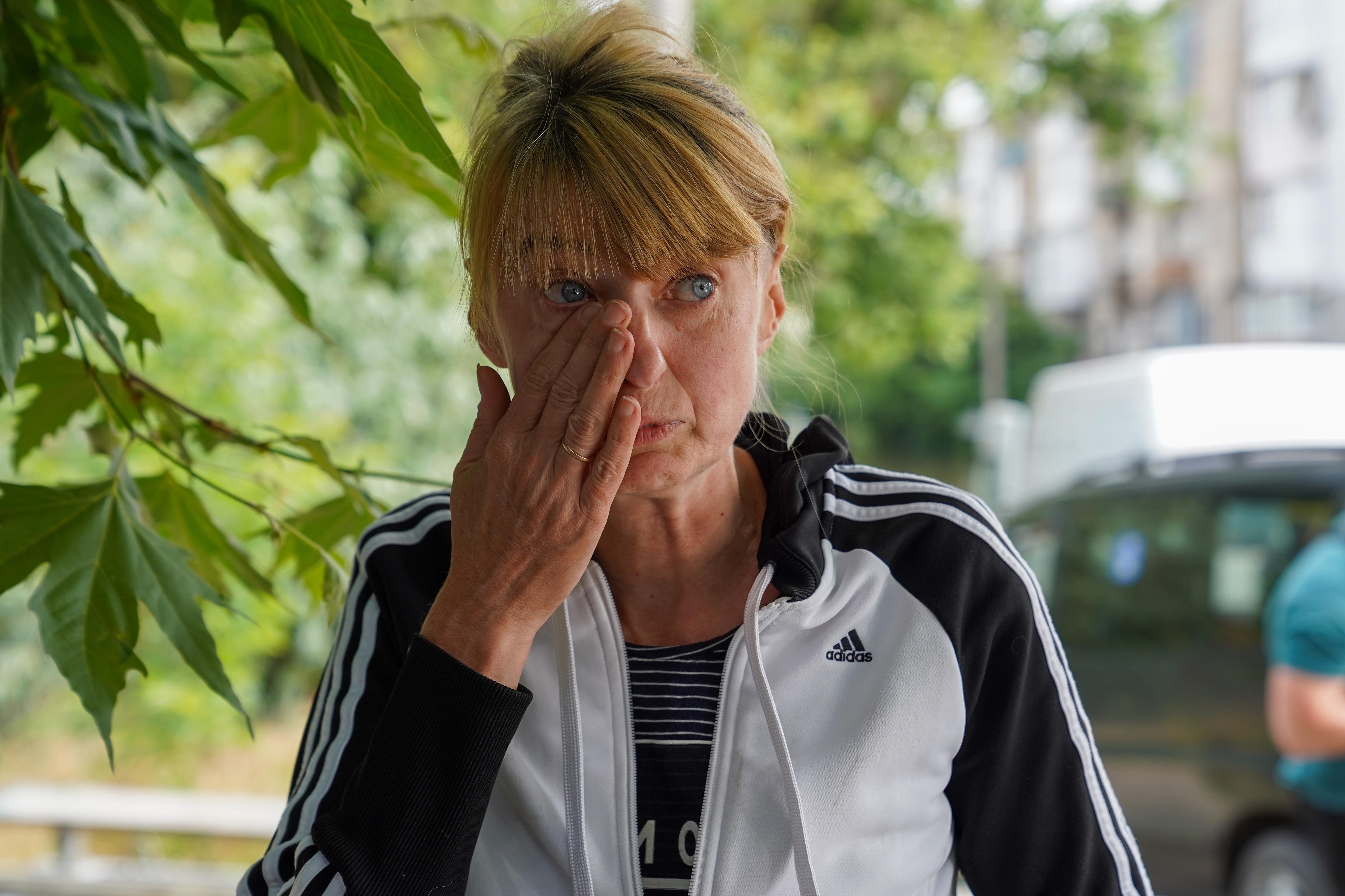 A blonde woman wipes a tear away