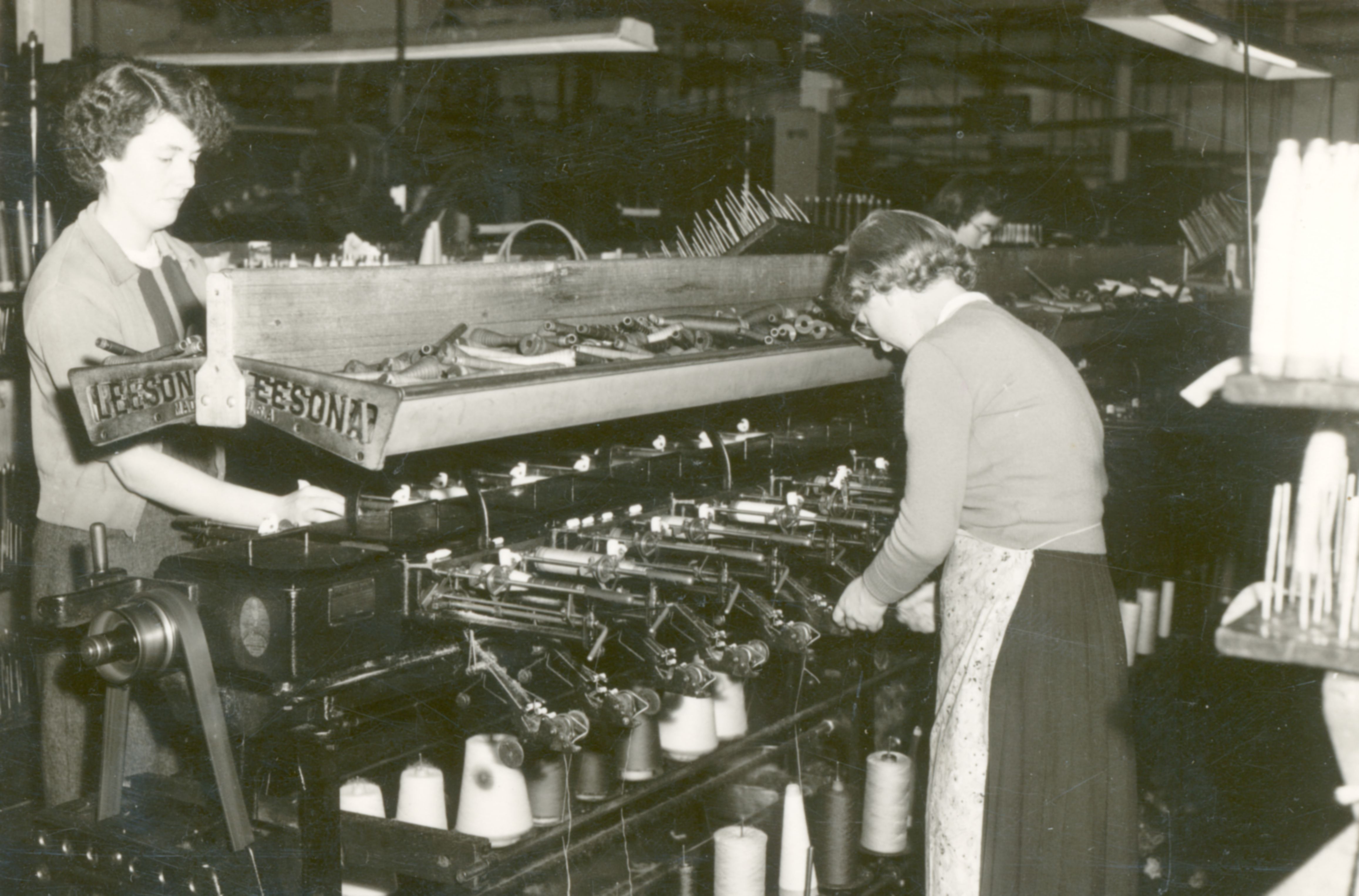 Las mujeres trabajan las máquinas en Albany Woolen Mills. 