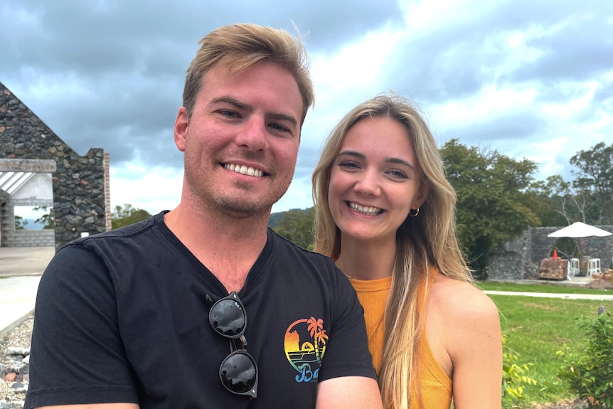 A man and woman smile at the camera