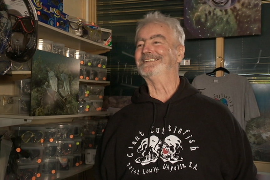 A smiling man at the front counter of his shop.