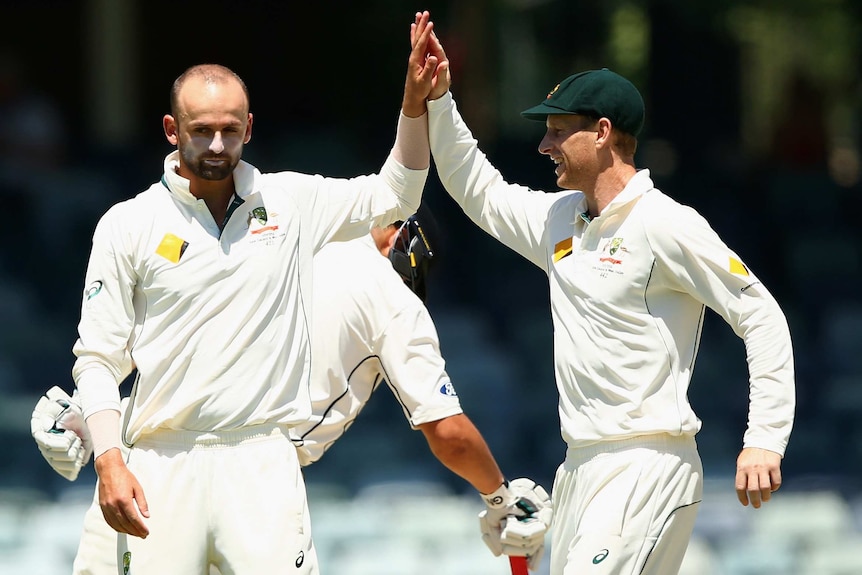 Australia's Nathan Lyon celebrates the wicket of NZ's Mark Craig with Adam Voges at the WACA.