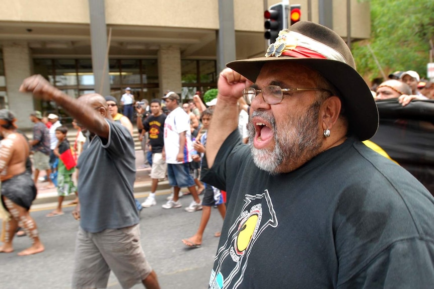 Sam Watson marches in Brisbane with fist pumping in the air.