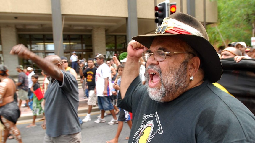 Sam Watson marches in Brisbane with fist pumping in the air.