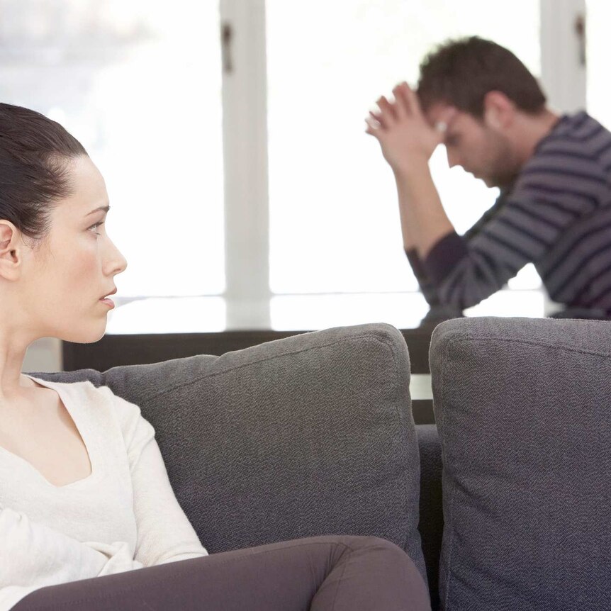 woman and man on couch looking stressed and in a fight