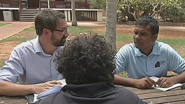 Lawyer, interpreter and Aboriginal client sitting outside Broome Court