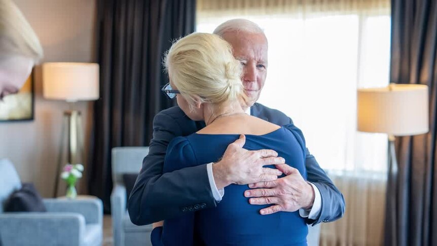 A man hugs a woman.