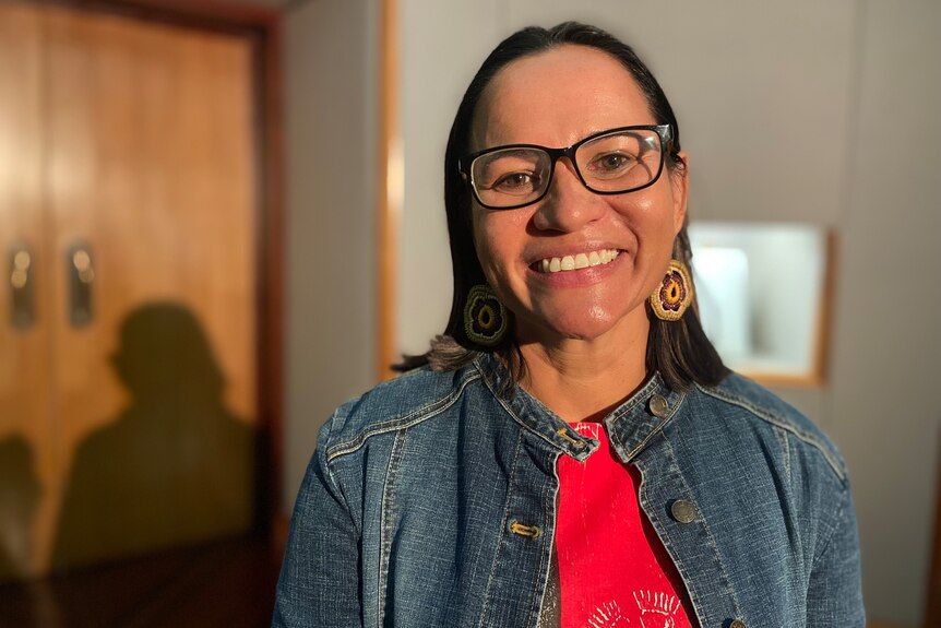 An Indigenous female doctor smiles at a launch at parliament.