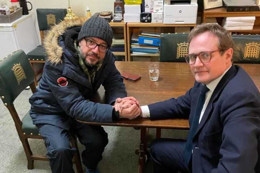 two men locking hands over a table