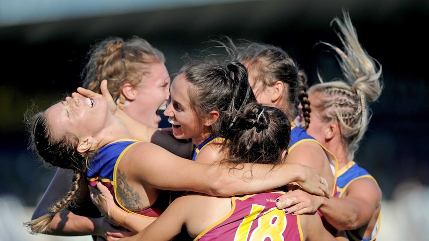 Brittany Gibson of the Lions(far left) celebrates with team-mates after she kicked a goal