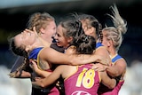 Brittany Gibson of the Lions(far left) celebrates with team-mates after she kicked a goal