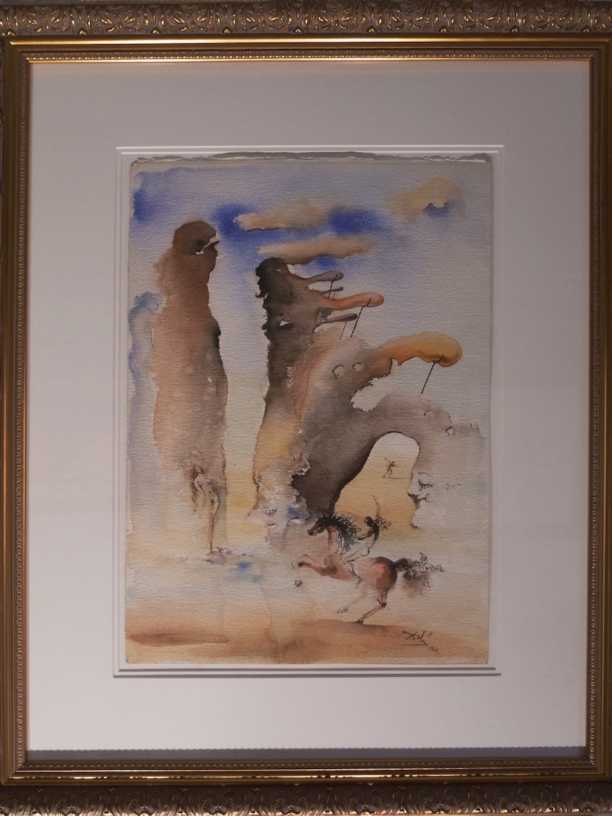 A multi-coloured watercolour piece of art in a gold frame