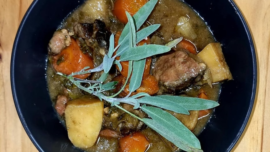 A bowl of Irish stew with a lovely sprig of herbs on top