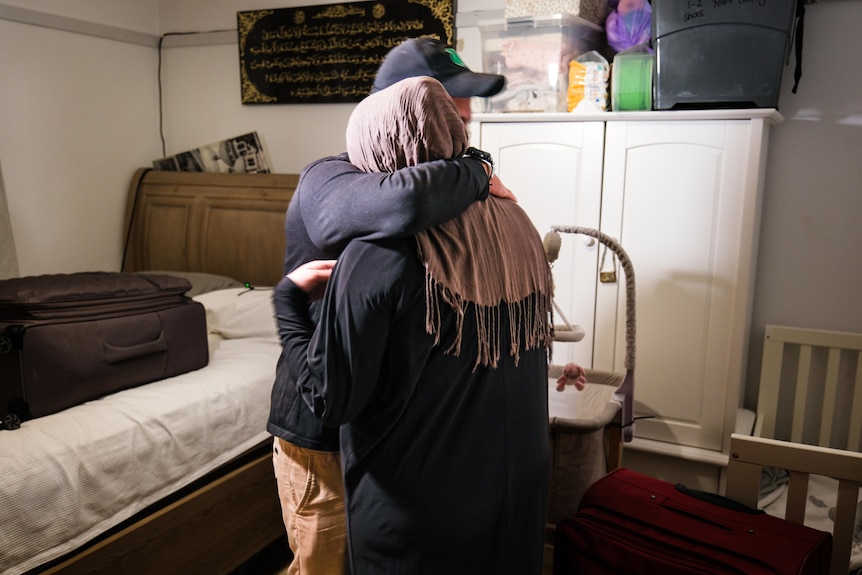 Man and woman embrace in bedroom