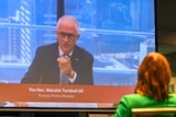 Malcolm Turnbull appearing on video with a cityscape in the background. 