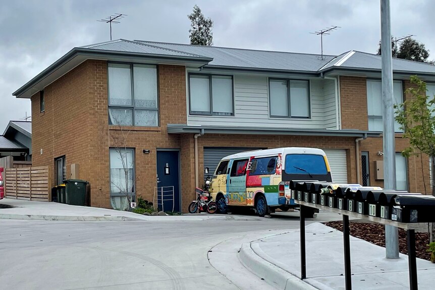 A block of units with vans out the front.