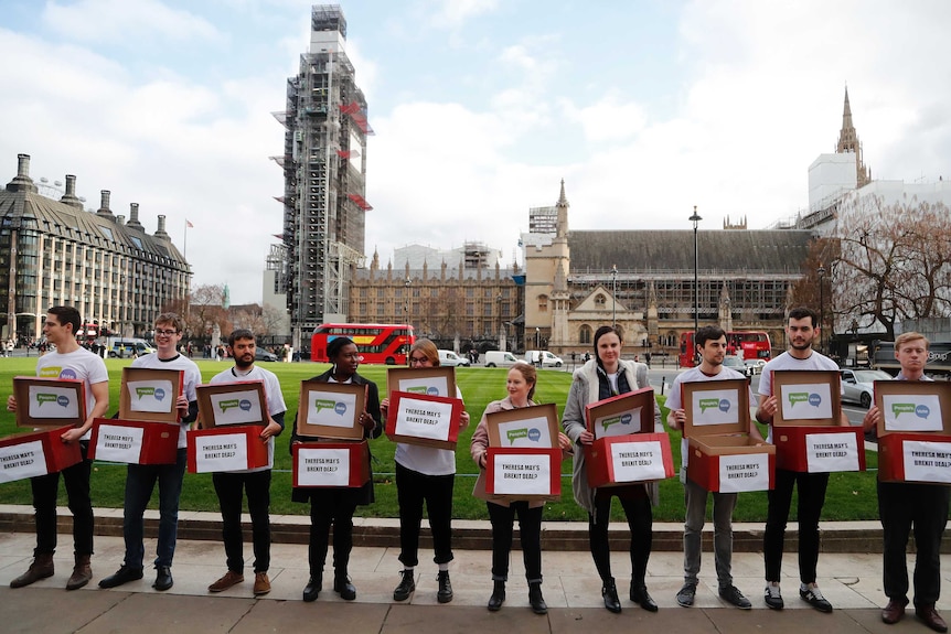 Activists from the People's Vote campaign stand in a row while holding 'Deal or No Deal' boxes in London.