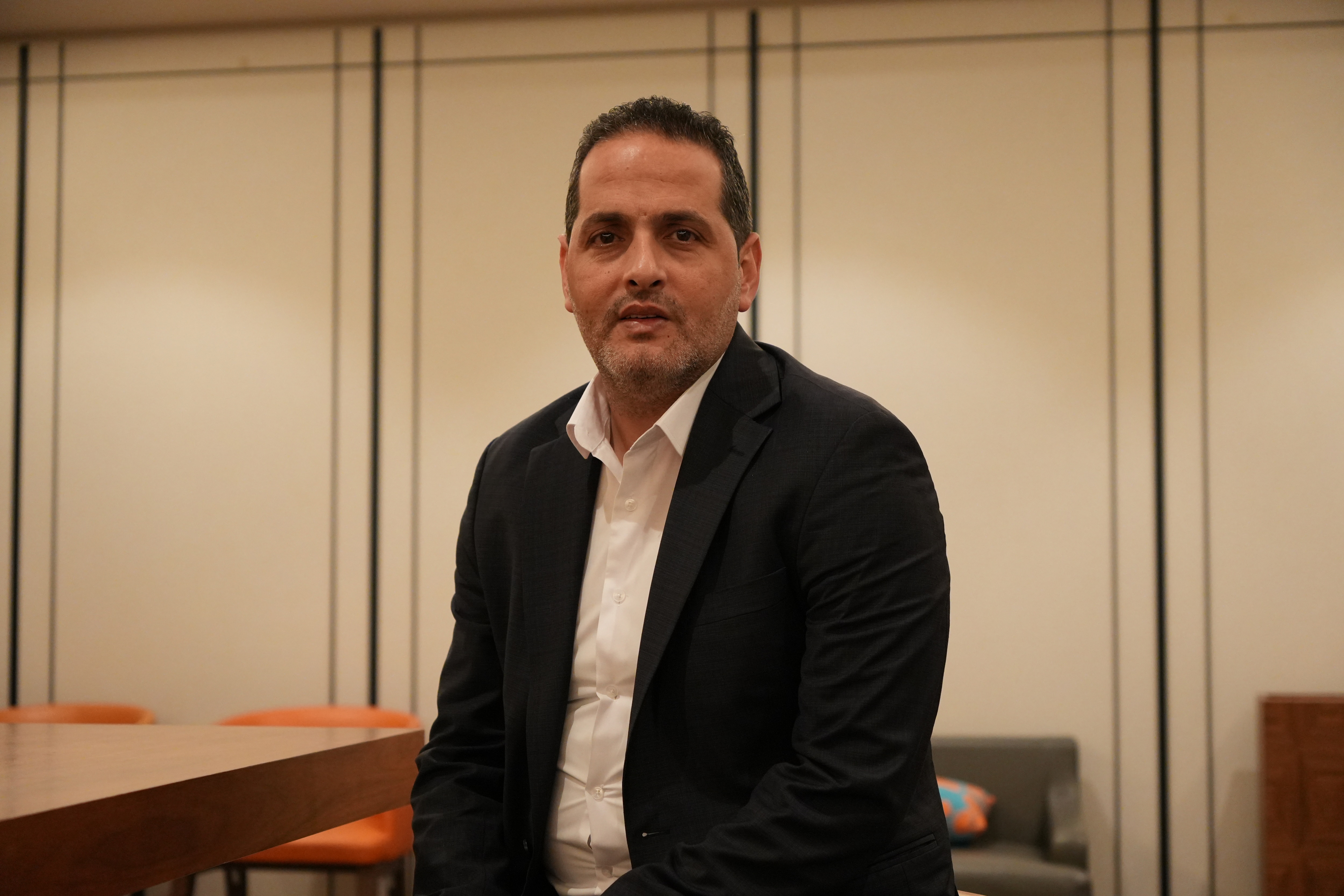 Firas Abu Hilal wearing a dark jacket, sitting in an office.