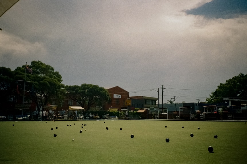 Multiple lawn bowl balls on the green of a bowling club