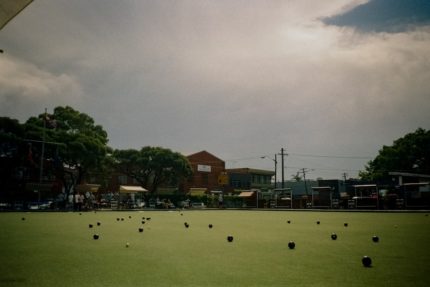 Múltiples bolas de césped en el green de un club de bolos