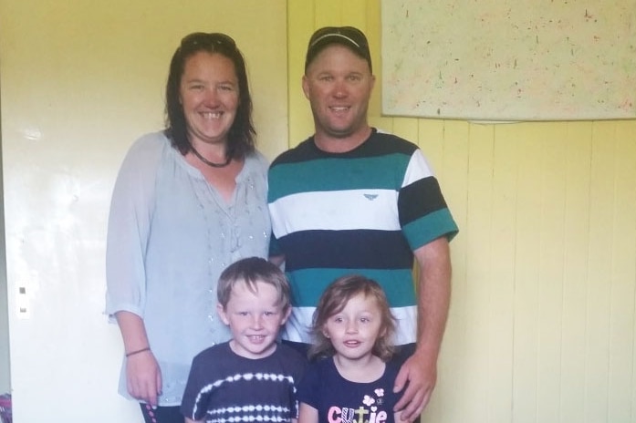 Katie Fuller stands with her family in room in a house.