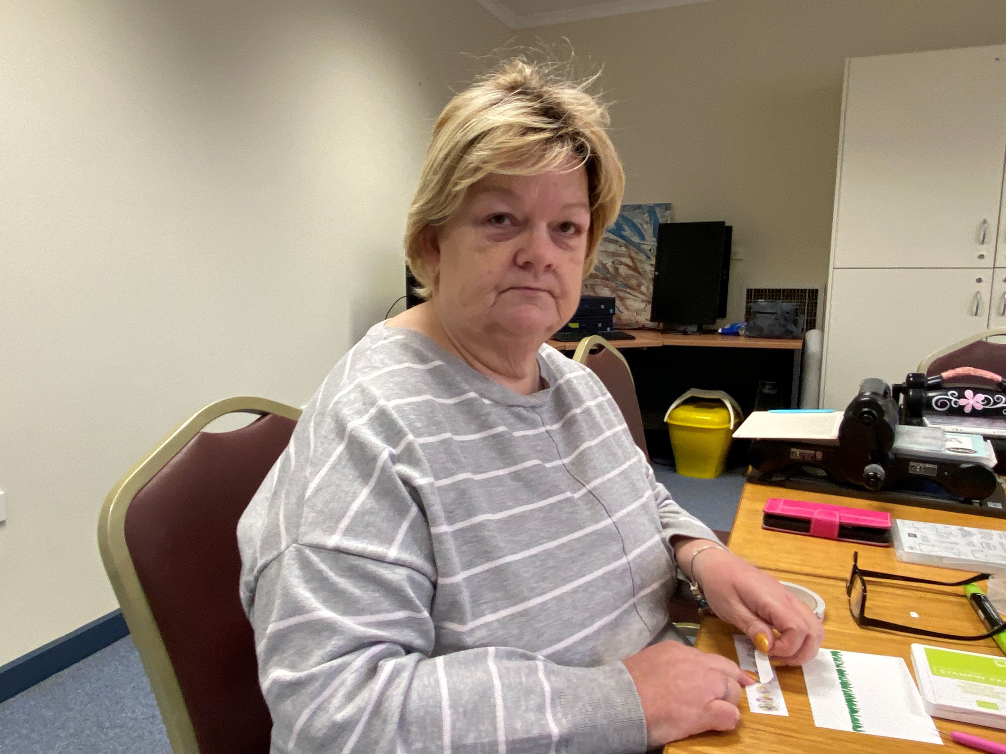 A woman sitting at a table looking at the camera 