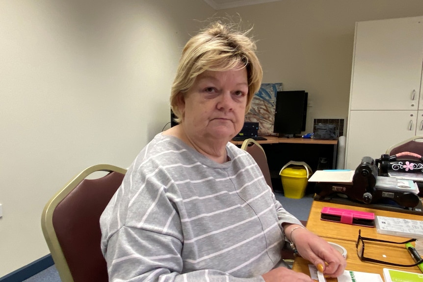 A woman sitting at a table looking at the camera 