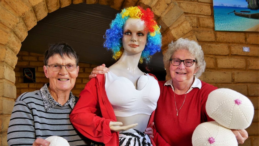 Dawn Hortin and Robin Bromilow pose with some Knitted Knockers and a mannequin wearing a pair of the cotton breast prostheses.