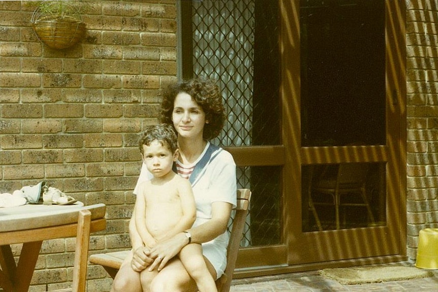 Young boy sitting on his mum's lap