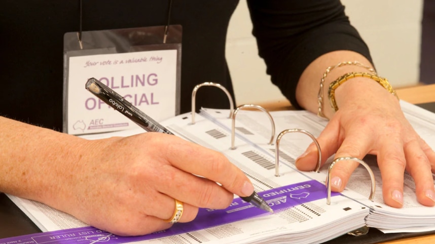 An AEC staff member is writing notes.