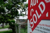 A house with a sold sign in the front yard.