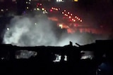 Smoke rises over a city at night in the aftermath of a missile attack.