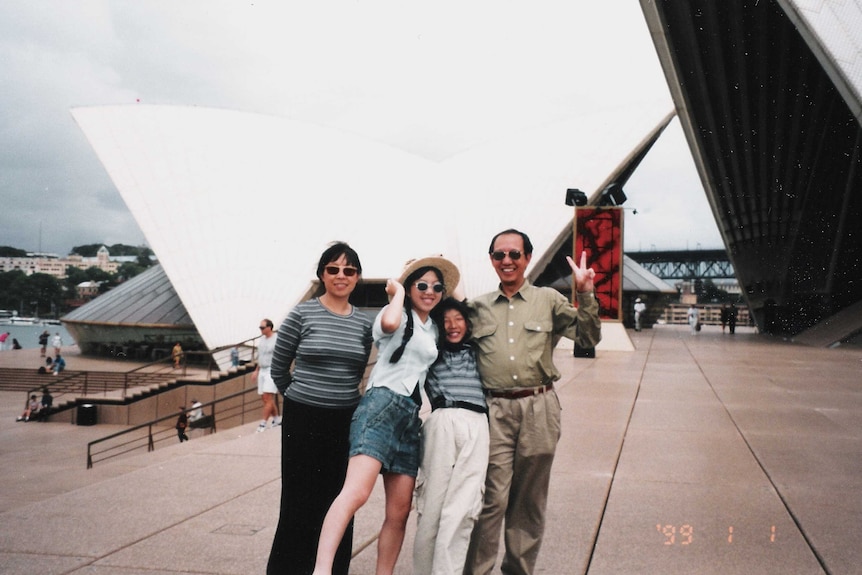 A family of four, including the parents and two children were smiling in front of the Sydney Opera House