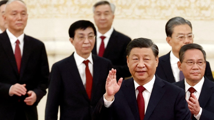 Xi Jinping waves as new Standing Committee members follow behind.