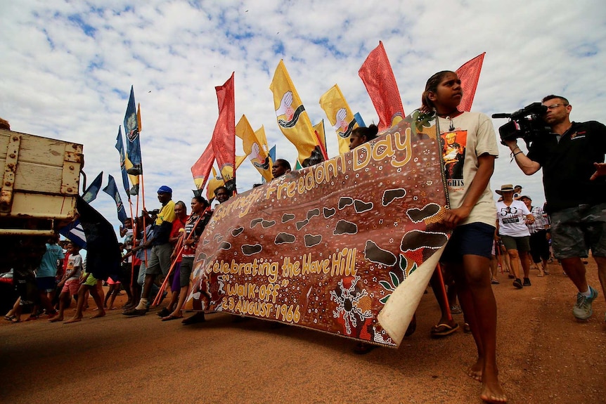 Marchers carrying a banner saying 'Gurindji Freedom Day'.