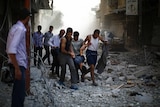 Wounded man carried after airstrike over Syria