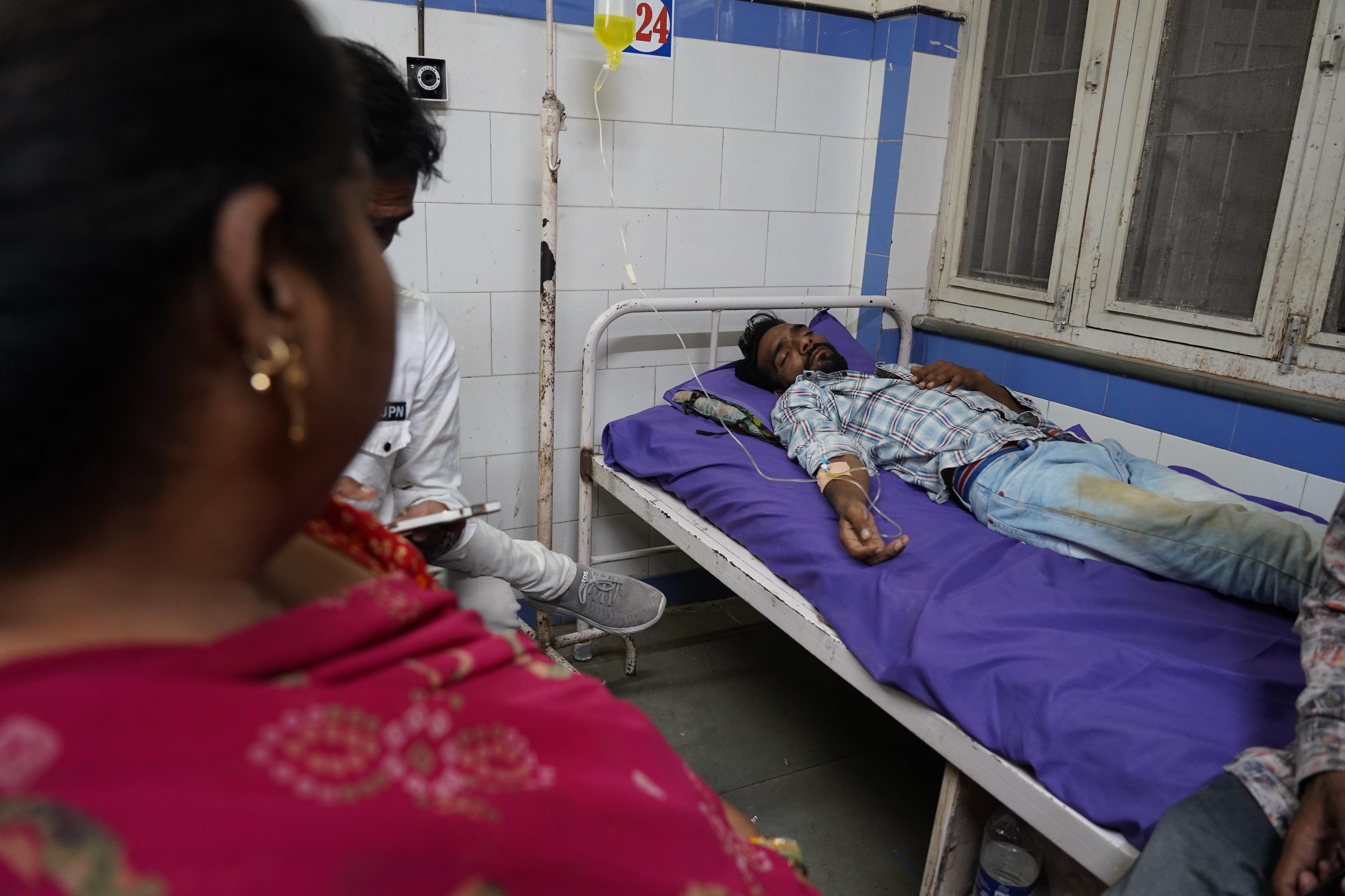 A man is lying in a hospital bed with an IV.
