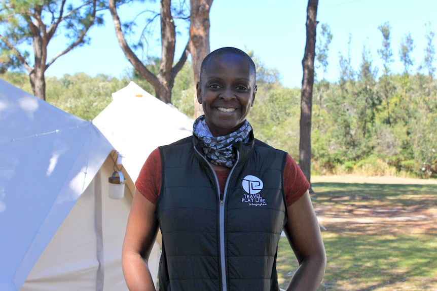 Kemi Nekvapil standing in front of tents at Women's Adventure Summit in Forster, NSW.