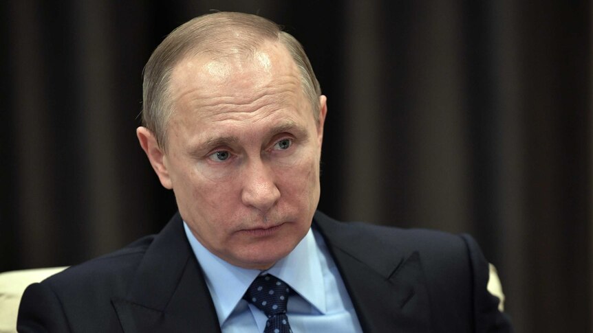 Russian President Vladimir Putin listens during a meeting.