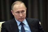 Russian President Vladimir Putin listens during a meeting.