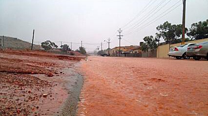 Floodwaters carry red dirt