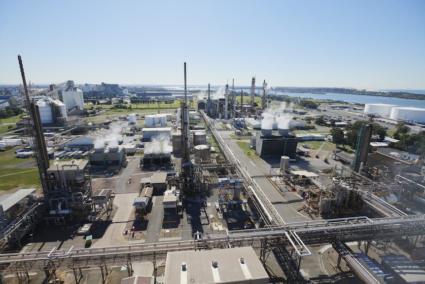 An aerial view of the plant with numerous chimneys and steam coming out of them.