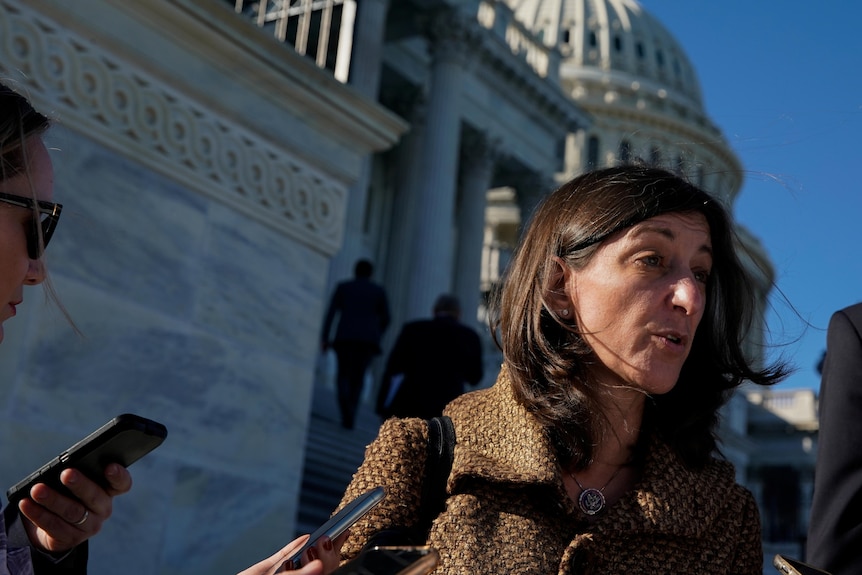 A woman with dark bobbed hair talks outside the US Capitol building