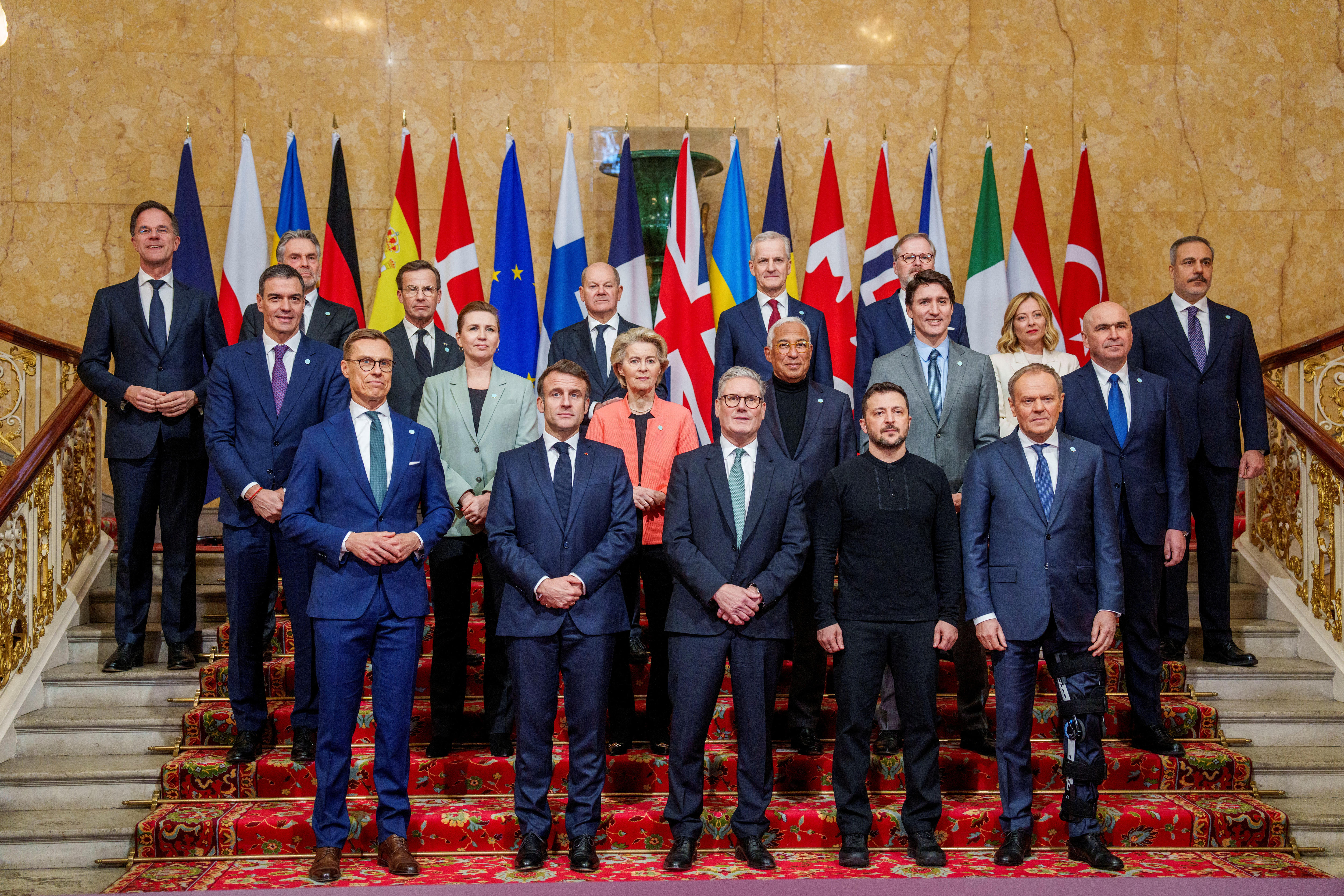 World leaders pose for a photo on a staircase.